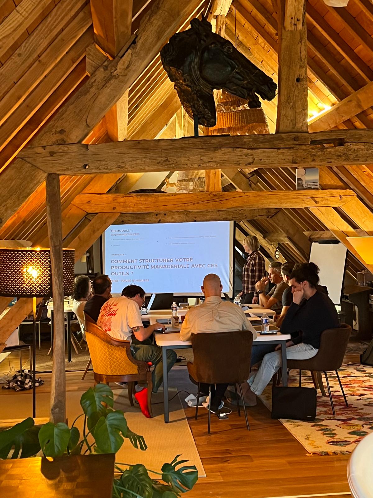 Espace de coworking sous charpente de La Longère Cogite pendant une formation résidentielle IA